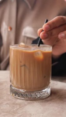 Sıcak bir atmosferde el buzlu kahveyi karıştırır, eğlenmeye hazırdır..