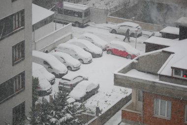 Sakin bir mahallede yoğun kar yağışı battaniyeleri araçlar ve caddeler.