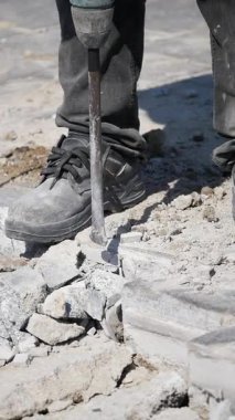 İşçi inşaat alanında beton kırmak için matkap kullanıyor..