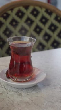 Sıcak bir ortamda geleneksel Türk çayının tadını çıkarıyorum.,