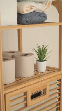 Havluları ve tuvalet kağıtları olan şık bir banyo deposu. .