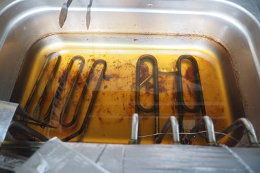 Yemek ekipmanları mutfak ortamında yağ ve ısıtma elementleri gösteriyor.