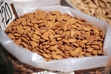 Bir pazar ortamında büyük bir yığın taze badem sergileniyor..