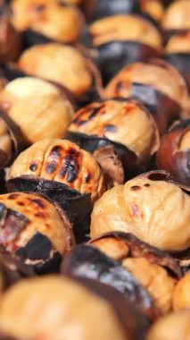 Kalabalık bir pazarda sıcak, ızgara kestanenin tadını çıkarın..