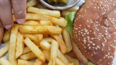 Lezzetli bir hamburger, yanında da turşulu patates kızartması..