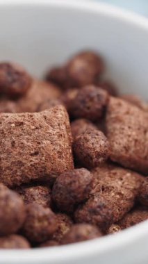 Lezzetli çikolatalı kahvaltı gevreği beyaz kaseyi gevrek lokmalarla doldurur..