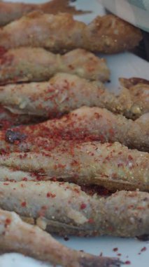 Lezzetli balık çubukları, üzerinde baharat olan bir tabakta sunulur..