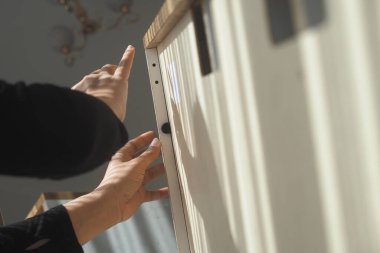 Güneş ışığıyla aydınlatılmış bir alanda dolap kapısını dikkatlice yerleştirin..