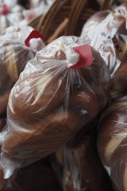 Bir markette satılık sıcak kahverengi ekmek torbaları var..