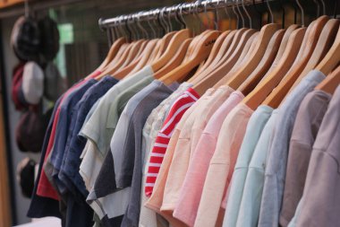 Değişik renklerde gömlekler perakende alanındaki ahşap askılara güzelce asılır..