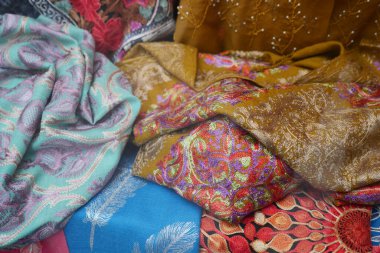 Parlak renkli kumaşlar pazarda satılmak üzere güzelce düzenlenmiş..