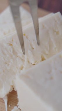 Basit servis fikirleri için taze peynirin çatalla kesilmesini izleyin..