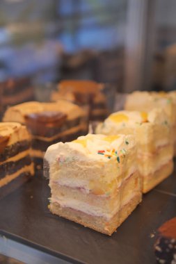 Bir dükkanda sergilenen kremalı ve şekerli keklerden oluşan bir seçim..