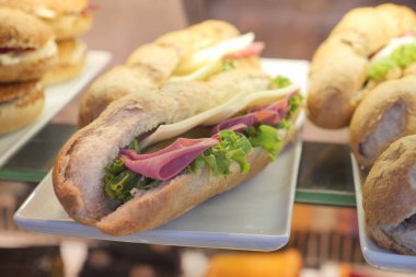 Bir dükkânda sergilenen etli ve taze sebzeli lezzetli bir sandviç..