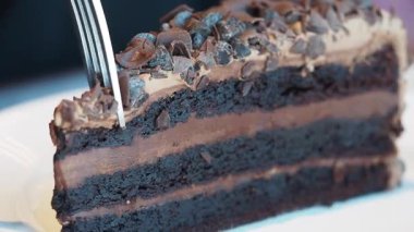 Chocolate cake is sliced to reveal rich layers and toppings.