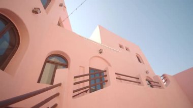 Discover the vibrant design of a pink building in Morocco under the blue sky.