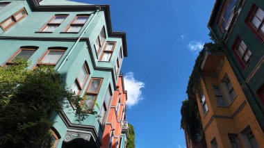 Işıl ışıl boyanmış binalar canlı bir bölgede güneşli mavi bir gökyüzünün altında dimdik duruyorlar..