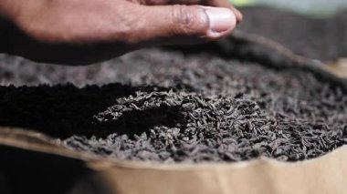 Explore the details of loose black tea leaves in a market setting.