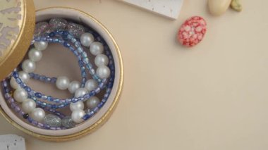 Beautiful beads and pearls are arranged inside a charming container.