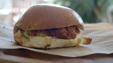 Enjoy a delicious chicken sandwich made with fresh ingredients at a cozy cafe.