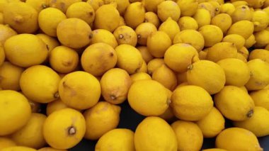Countless fresh lemons create a bright display in the market.