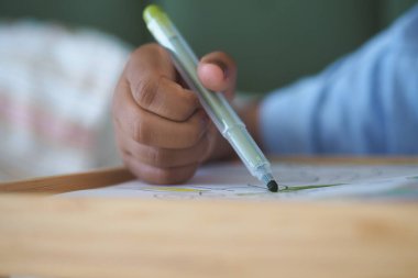 Bireyler yeşil kalemle kağıt üzerinde renkli sanatlar yaratıyorlar..