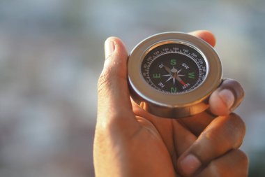 Bir insan doğada gezinirken bir pusula tutar..