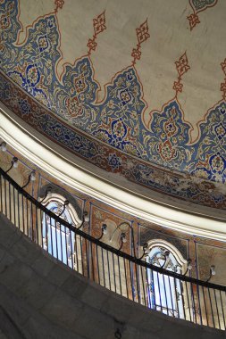 Dekoratif desenler ve kemerler çarpıcı bir tavan tasarımını vurguluyor.