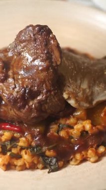 Delicious meal featuring tender meat atop a bed of spiced grains and vegetables.