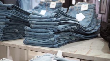 Denim jeans neatly arranged on a table in a retail store.
