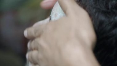 A barber skillfully applies shaving cream during a grooming session.