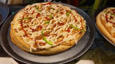 Savor the taste of pizza topped with creamy sauce and fresh vegetables.