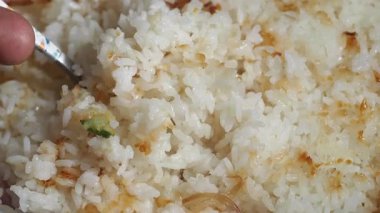 Watch how to prepare delicious fried rice with fresh vegetables and herbs.