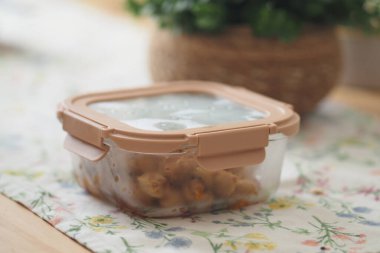 Yemek depolu bir masada bitkilerle dolu temiz bir kabın içinde saklanır..