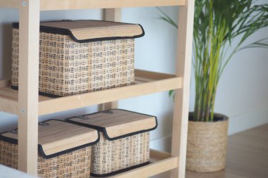 Şık sepetler bir bitkinin yanındaki rafta sergilenir..