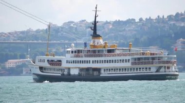 Feribot berrak bir gökyüzünün altında zarif bir şekilde hareket eder..