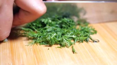 Tahta üzerinde ustalıkla doğranan taze bitkilerin yakın plan görüntüsü..