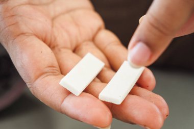 Evlerinde avuçlarında iki sakız tutan bir adam..