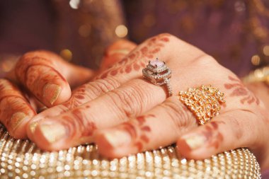 Kutlama sırasında kadın eli, ayrıntılı kınalar ve güzel yüzükler sergiliyor..