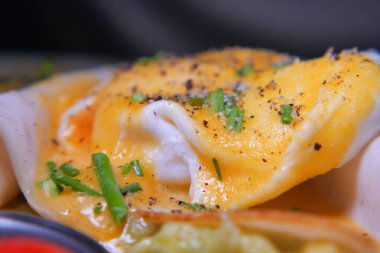 Freshly made eggs benedict topped with herbs and spices served hot.