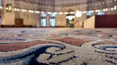 Zarif bir camide yumuşak ışıklandırmalı renkli bir halıya yakından bakın..