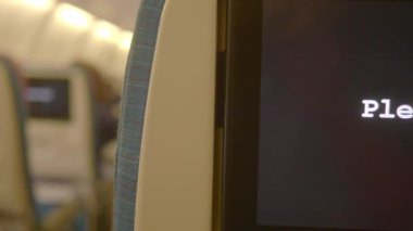 Uçağın içinde boş koltuklar ve eğlence ekranları var..