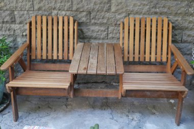 Merkezi masalı iki ahşap sandalye taştan bir duvara dayanıyor..