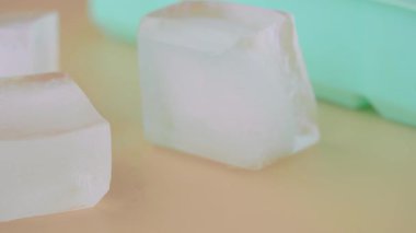 Buz küpleri parlak, sıcak bir ışığın altında yavaşça eriyip gidiyor..