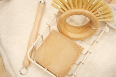 Tahta bir fırça ve sabun beyaz bir havluya oturur, sıcak bir spa hissi yaratır..