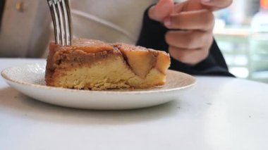 Öğleden sonra bir kafede nefis bir dilim pastanın tadını çıkaran bir insan..