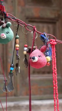 Eşsiz tığ işi anahtarlıklar canlı bir pazarda bir tezgahta asılı duruyor..