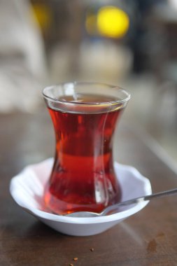 Tahta masada bir bardakta servis edilen dumanı tüten Türk çayı..