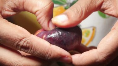 Eller nazikçe incir meyvesini sıkıp hazır olup olmadığını kontrol eder. 