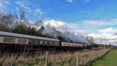 Preserved steam locomotive Royal Scot heads the Lakelander, through Southwaite, Cumbria on the west coast mainline in northern England.